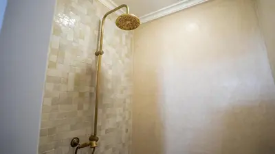 a bathroom with a shower with tiled walls at Manzil Fanny Private Riad & Spa in Marrakech