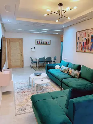 a living room with a green couch and a table at 2BRCentral GuelizYSLMajorelle Netflix&100MBfibre in Marrakech