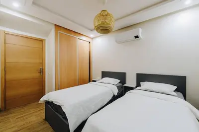 two beds in a room with a door at 2BRCentral GuelizYSLMajorelle Netflix&100MBfibre in Marrakech