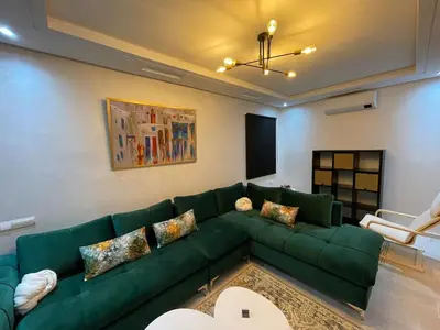 a living room with a green couch and a fireplace at 2BRCentral GuelizYSLMajorelle Netflix&100MBfibre in Marrakech