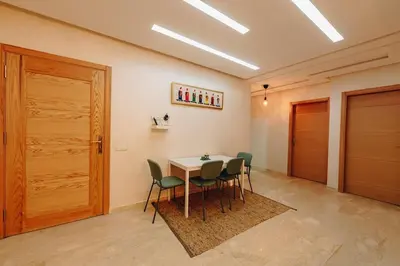 a room with a table and chairs and a door at 2BRCentral GuelizYSLMajorelle Netflix&100MBfibre in Marrakech