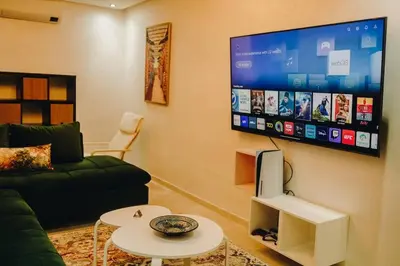 a living room with a couch and a flat screen tv at 2BRCentral GuelizYSLMajorelle Netflix&100MBfibre in Marrakech