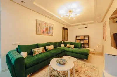 a living room with a green couch and a table at 2BRCentral GuelizYSLMajorelle Netflix&100MBfibre in Marrakech