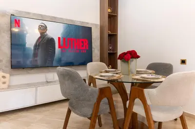 a dining room with a table and a tv at Appartement 2 Chambres Proche Médina Centre Marrakech in Marrakech