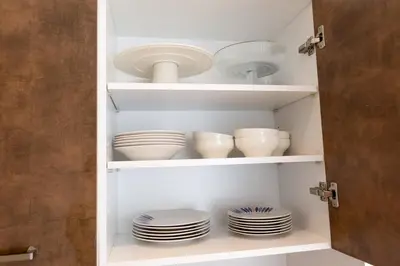a cupboard with plates and bowls and dishes at Appartement 2 Chambres Proche Médina Centre Marrakech in Marrakech