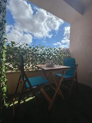 a table and two chairs sitting on a balcony at Appartement 2 Chambres Proche Médina Centre Marrakech in Marrakech