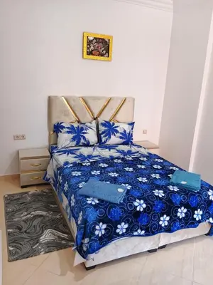 a bedroom with a bed with blue and white sheets at Appartement Lady Plaza 1 in Marrakech