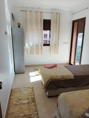 a bedroom with two beds and a window at Appartement Lady Plaza 1 in Marrakech