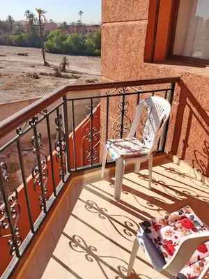a balcony with two chairs and a view of the desert at Appartement Lady Plaza 1 in Marrakech
