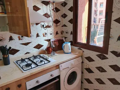 a kitchen with a stove and a washing machine at Appartement Lady Plaza 1 in Marrakech