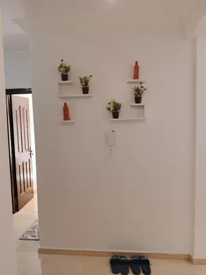 a pair of shoes sitting on the floor next to a white wall at Appartement Lady Plaza 1 in Marrakech