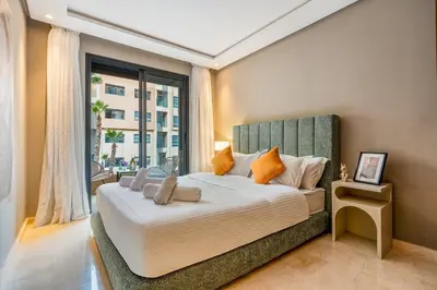 a bedroom with a large bed with a large window at Appartement Neuf et luxueux de 3 chambres proche du centre ville in Marrakech