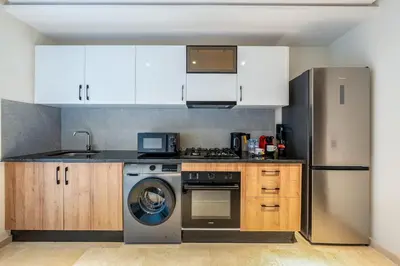 a kitchen with white cabinets and a dishwasher at Appartement Neuf et luxueux de 3 chambres proche du centre ville in Marrakech