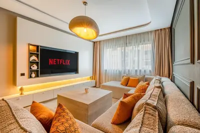 a living room with a couch and a tv at Appartement Neuf et luxueux de 3 chambres proche du centre ville in Marrakech