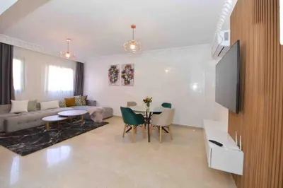 a living room with a couch and a table at Appartement Haut Standing Hivernage, Piscine, Centre Marrakech in Marrakech