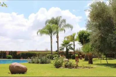 a garden with palm trees and a swimming pool at Appartement Haut Standing Hivernage, Piscine, Centre Marrakech in Marrakech