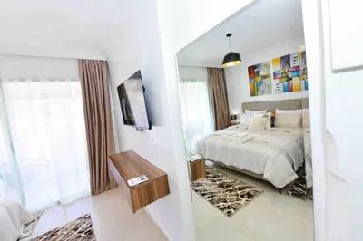 a bedroom with a bed and a mirror at Appartement Haut Standing Hivernage, Piscine, Centre Marrakech in Marrakech