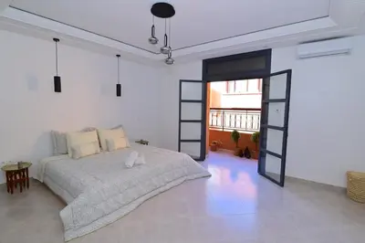 a bedroom with a bed in a white room at Appartement spacieux de 3 chambres à gueliz in Marrakech