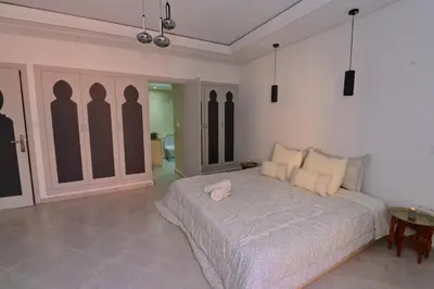 a bedroom with a bed with a pink pillow on it at Appartement spacieux de 3 chambres à gueliz in Marrakech