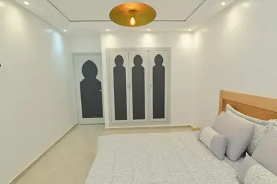 a bedroom with a bed and a wall with a closet at Appartement spacieux de 3 chambres à gueliz in Marrakech