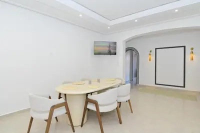 a dining room with a table and white chairs at Appartement spacieux de 3 chambres à gueliz in Marrakech