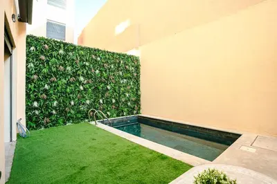 a backyard with a swimming pool and a green hedge at 5-Star Duplex - Private Pool in Marrakech