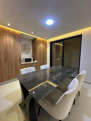 a dining room with a black table and white chairs at Luxury Villa Marrakech in Marrakech
