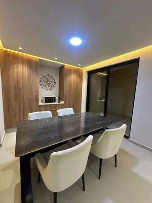 a dining room with a black table and white chairs at Luxury Villa Marrakech in Marrakech