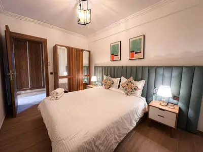 a bedroom with a large bed and two tables with lamps at Well equipped luxury apartment in centre marrakech ctm aeroport train medina in Marrakech