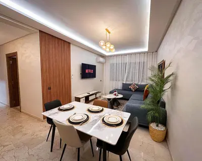 a living room with a table and a couch at Well equipped luxury apartment in centre marrakech ctm aeroport train medina in Marrakech