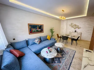 a living room with a blue couch and a table at Well equipped luxury apartment in centre marrakech ctm aeroport train medina in Marrakech
