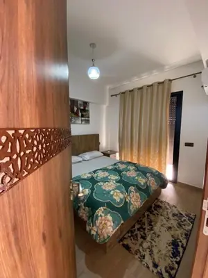 a bedroom with a bed with a floral bedspread at Hivernage & Gueliz Luxury Apt Pool near medina in Marrakech