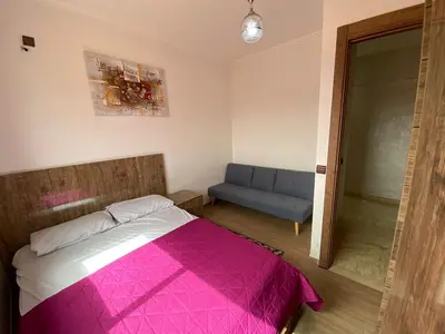 a bedroom with a pink bed and a blue couch at Hivernage & Gueliz Luxury Apt Pool near medina in Marrakech