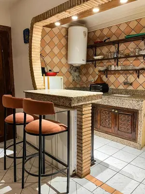 a kitchen with a counter and stools in a kitchen at appartement en résidence in Marrakech