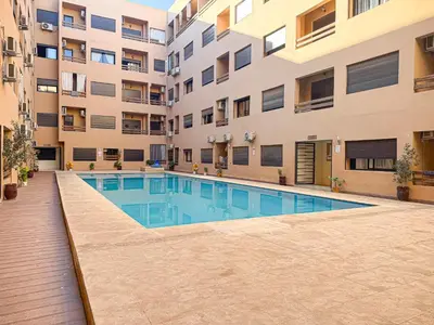 an apartment building with a swimming pool in front of a building at Oasis Gueliz - Piscine & parking privé in Marrakech