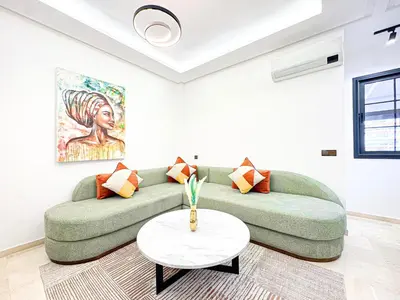a living room with a green couch and a table at Oasis Gueliz - Piscine & parking privé in Marrakech