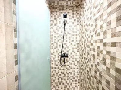 a shower in a bathroom with a tile wall at Oasis Gueliz - Piscine & parking privé in Marrakech