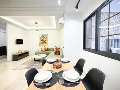 a dining room with a table and chairs and a couch at Oasis Gueliz - Piscine & parking privé in Marrakech