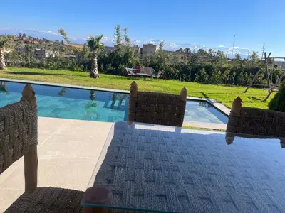 a couple of chairs sitting next to a swimming pool at Villa Lam in Marrakech