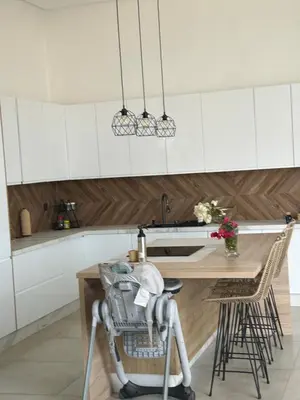 a kitchen with white cabinets and a wooden table at Villa Lam in Marrakech