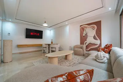 a living room with a couch and a table at Appartement Deluxe 2 chambres GUELIZ, Piscines, Spa, Gym in Marrakech