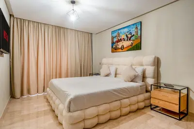 a bedroom with a large bed and a couch at Appartement Deluxe 2 chambres GUELIZ, Piscines, Spa, Gym in Marrakech