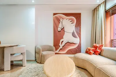 a living room with a painting of a horse on the wall at Appartement Deluxe 2 chambres GUELIZ, Piscines, Spa, Gym in Marrakech