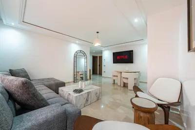a living room with a couch and a table at Appartement Deluxe 2 chambres GUELIZ, Piscines, Spa, Gym in Marrakech