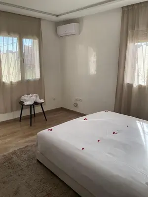 a bedroom with a white bed with red roses on it at jhome in Marrakech