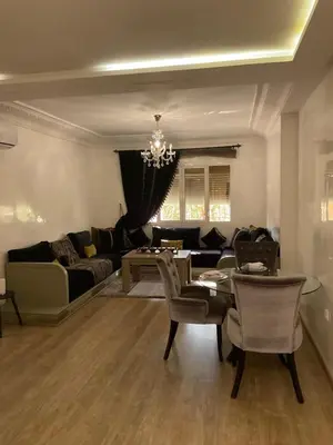 a living room with a couch and a table and chairs at jhome in Marrakech