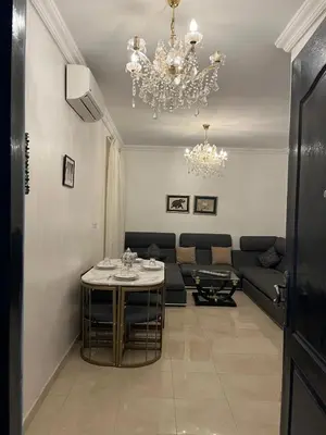 a living room with a table and a chandelier at Appartement cosy Marrakech in Marrakech