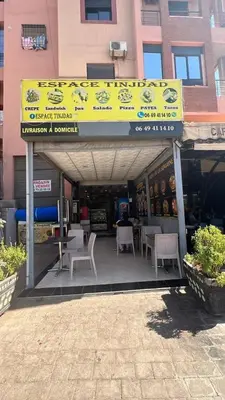 a restaurant with tables and chairs in front of a building at Appartement cosy Marrakech in Marrakech