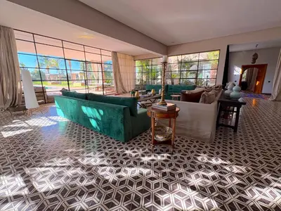 a living room with couches and tables and windows at Palais Meryem in Marrakech