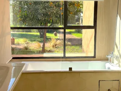 a bathroom with a bath tub and a window at Palais Meryem in Marrakech